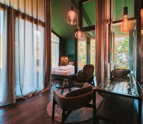 grüne Fliesen, Designerlampen und lange Vorhänge in der Suite