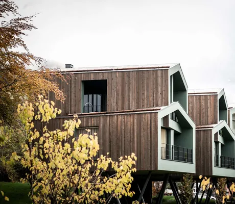 Chalets auf Stützen vor den winterlichen Dolomiten