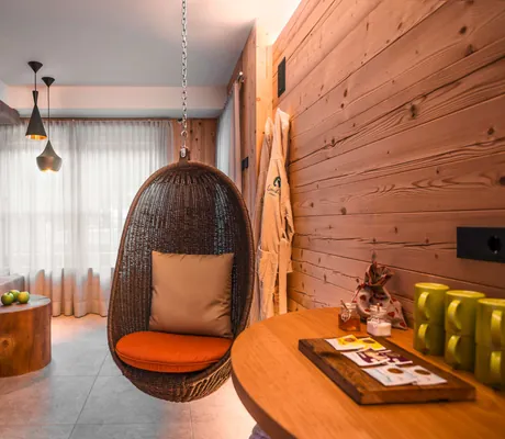 Korbhängesessel neben Tisch mit grünen Tassen