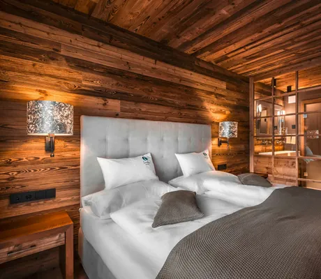 Doppelbett mit Glastür zum Badezimmer