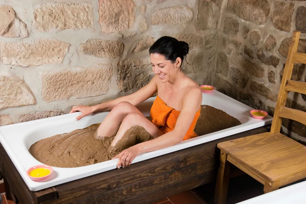Frau in Badewanne mit Lehm im Rahmen der Felke-Therapie