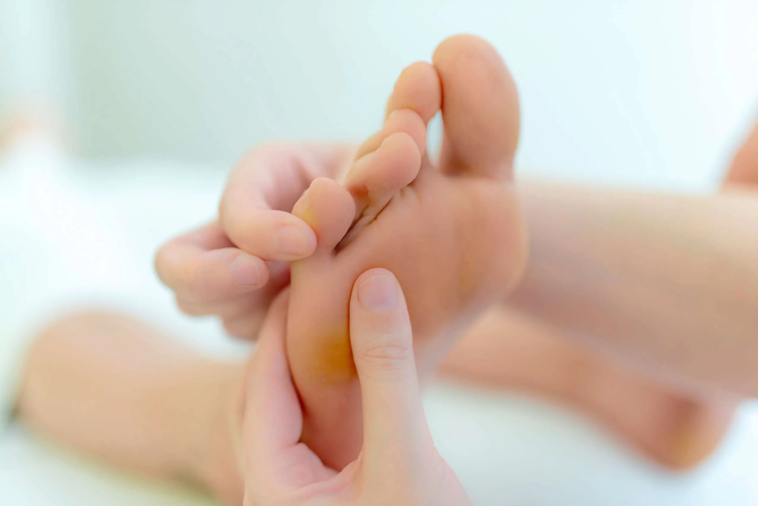 Physiotherapeutin macht Fußreflexzonenmassage