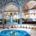 Blick auf ein schön gestaltetes Hamam mit Wasserbecken und bunten Mosaikfliesen