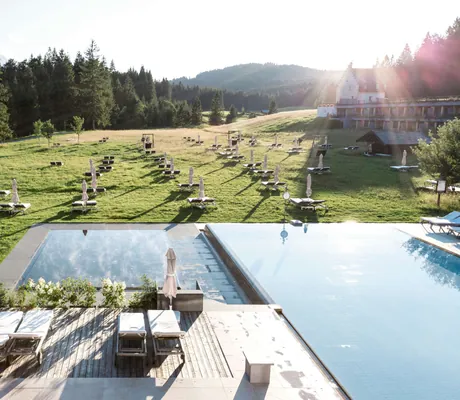 Außenpool mit weißen Schirmen inmitten der Buckelwiesen