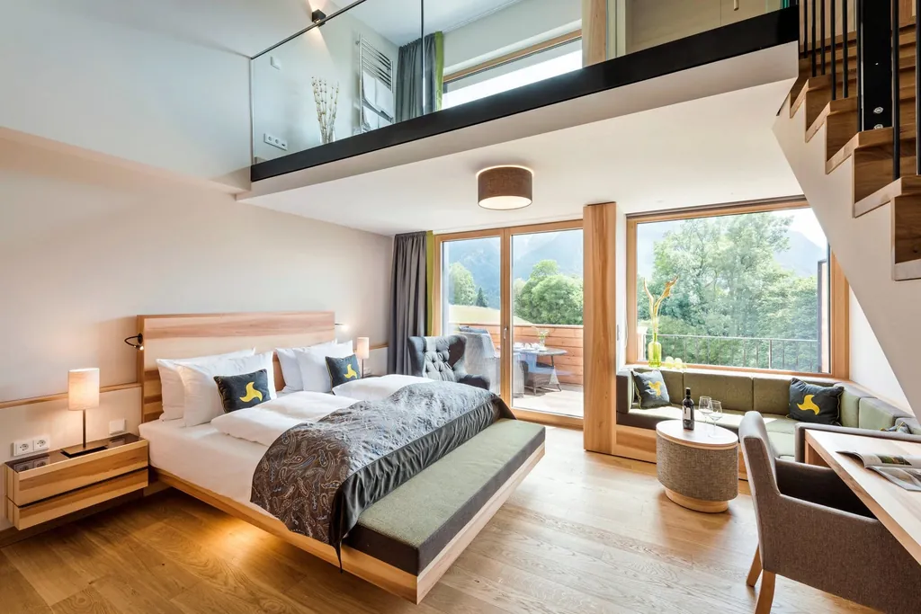 Loft Zimmer zweistöckig mit Bett, Sofa, Tisch, Stuhl und großen Fenstern