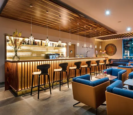 Bar aus Holz mit Holzdecke Barhockern und gemütlichen Sesseln