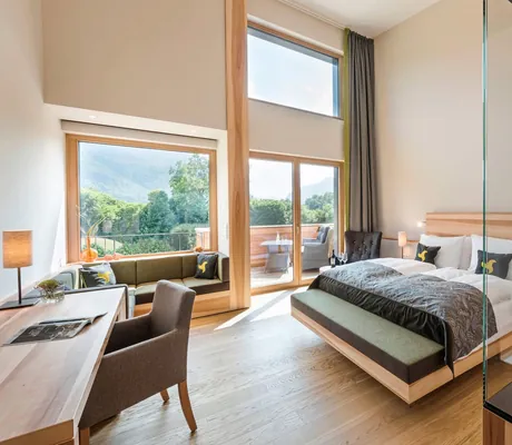 Großes helles Loft Hotelzimmer mit großen Fenstern und Bett