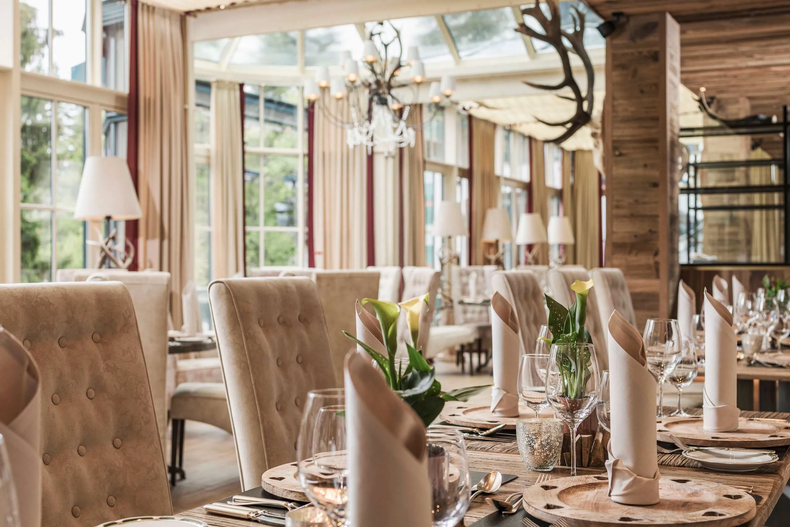 Restaurantinterieur mit eingedeckten Tischen im alpinen Wintergarten