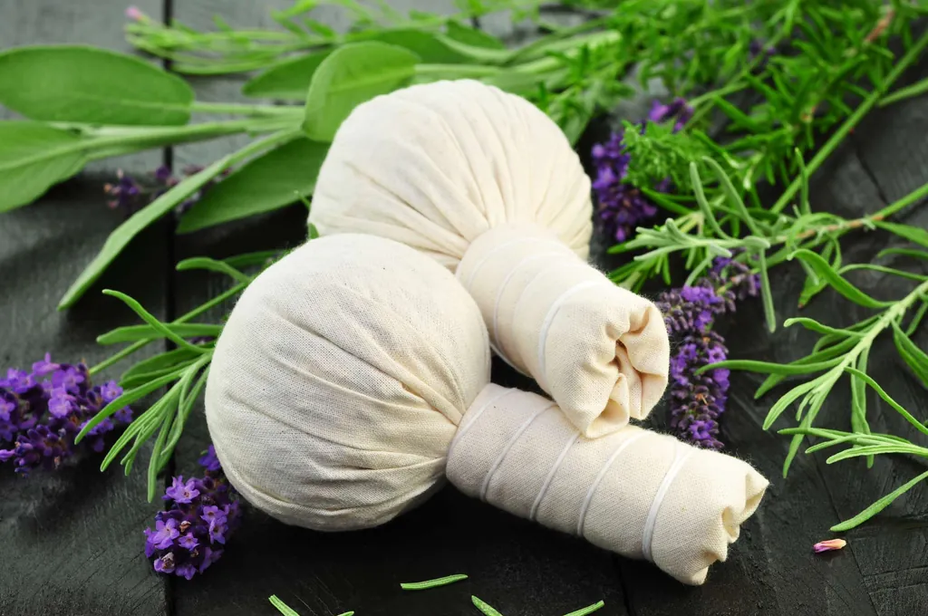 Zwei Kräuterstempel liegen auf einem schwarzen Tisch mit Gras und Blumen