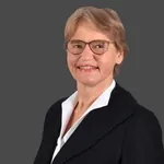 Andrea Scheidtweiler steht vor einem grauen Hintergrund