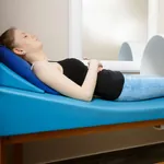 Frau liegt auf einer Liege und wird einer Magnetfeld-Therapie unterzogen