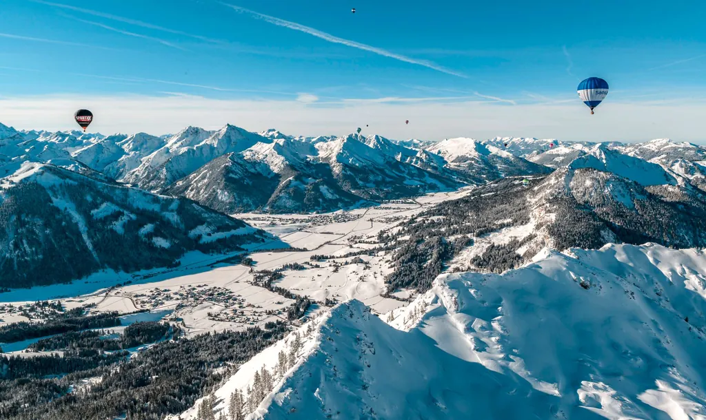 Blick auf das Tannheimer Tal im Winter mit zahlreichen Hei&szlig;luftballons