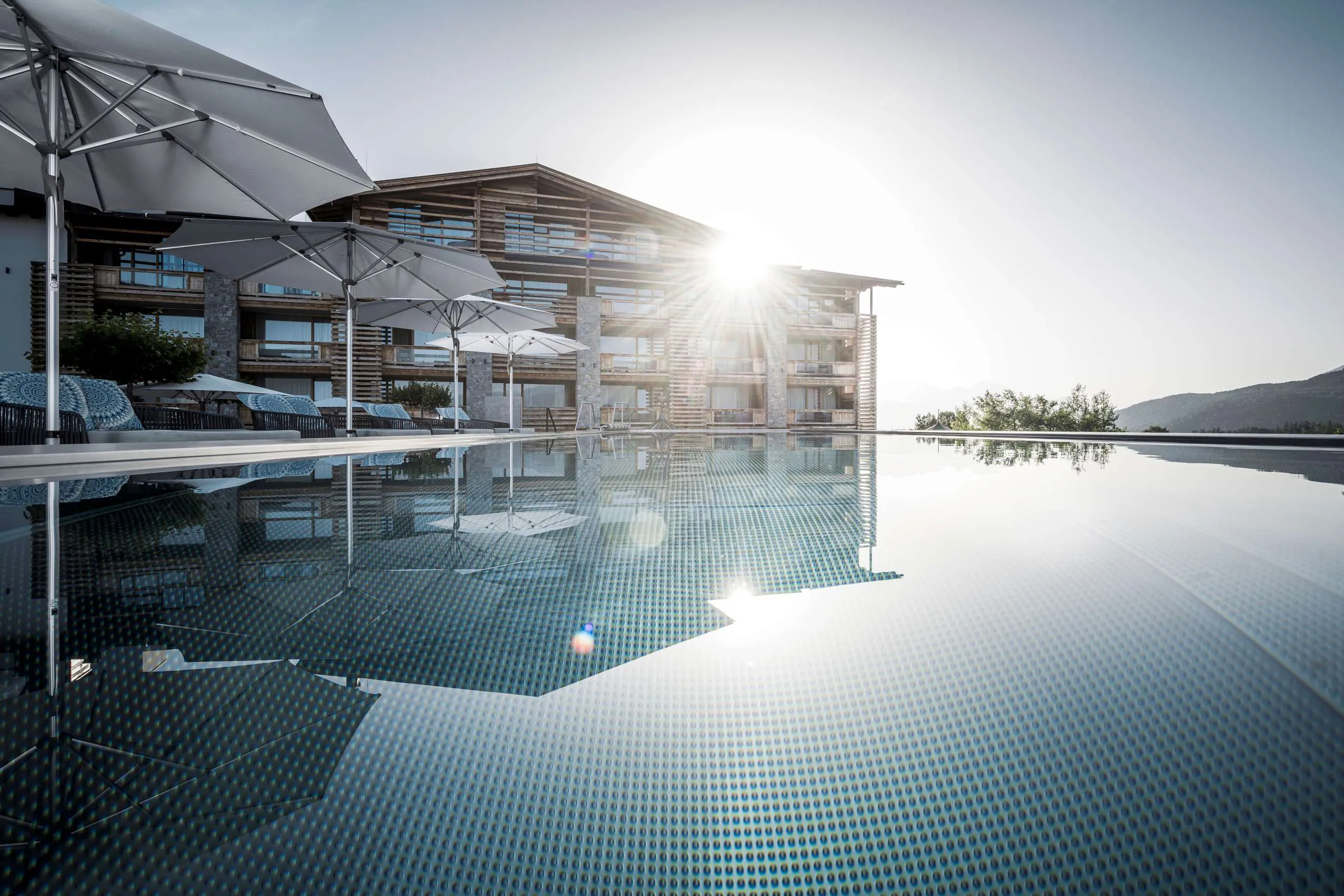 Im Vordergrund der Infintypool und im Hintergrund das Haus Alpenresort Schwarz