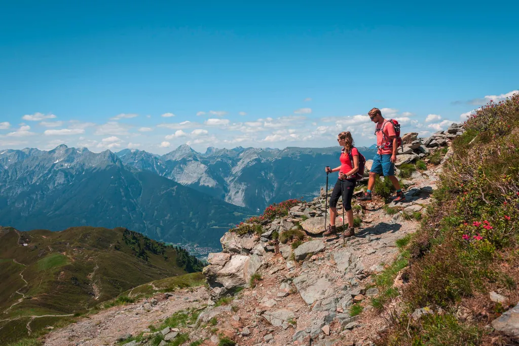 Eine Frau und ein Mann beim wandern auf einem Berg mit schönem Ausblick