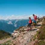 Eine Frau und ein Mann beim wandern auf einem Berg mit schönem Ausblick