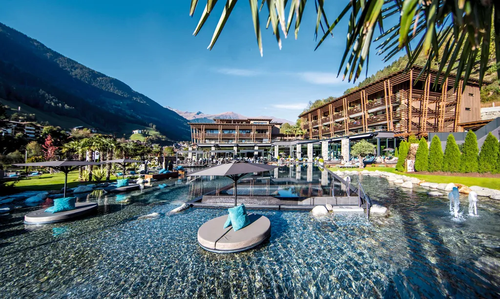 Blick auf den Pool und das Haus das Sporthotel Andreus Golf Lodge in S&uuml;dtirol