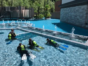 Tauchschule mit vier Teilnehmern im Outdoorpool des Quellenhof Luxury Resort Passeier in Südtirol