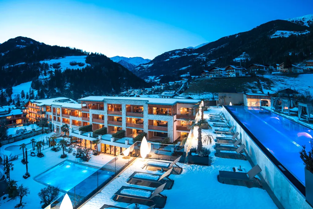 Au&szlig;enansicht auf den verschneiten Stroblhof in der D&auml;mmerung