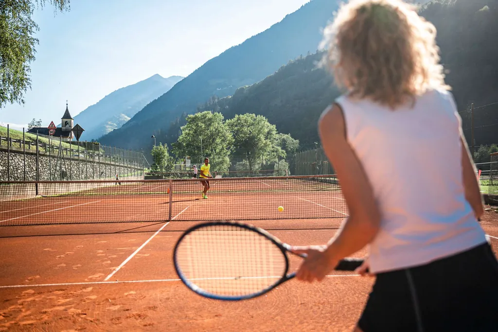Frau spielt Tennis auf dem Tennisplatz des Sporthotels Stroblhof