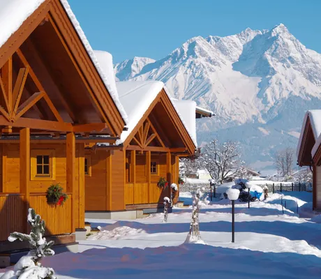 verschneite Hütten des Hundehotels Feriendorf Oberreit