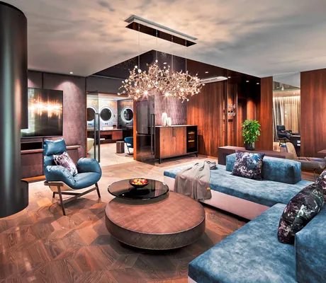 Ein Zimmer im Hotel Jagdhof mit einem großem Sofa, Wohzimmertisch und Sessel im Vordergrund