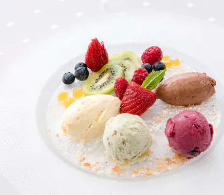 verschiedene Eis- und Mousse-Sorten mit frischem Obst