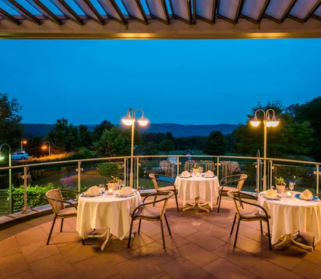 drei eingedckte runde Tische auf der Terrasse des Landhotel Heimathenhof