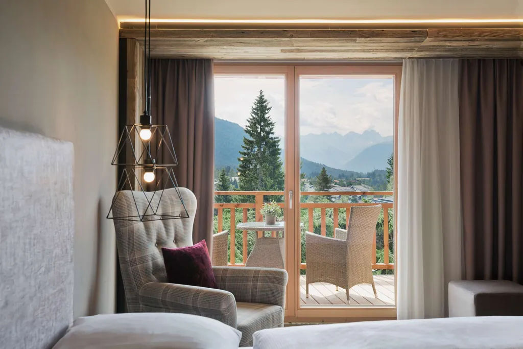 Blick aus dem Zimmer mit kariertem Sessel auf Balkon im Natur & Spa Hotel Lärchenhof