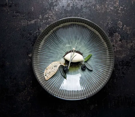 weiße Mousse auf grauem Teller in der Gourmetstube des Quellenhof Passeier