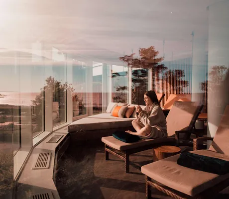 Frau auf Liege im runden Ruheraum im Strandhotel Ostseeblick