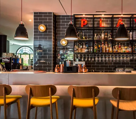 Bar mit gelben Barhockern im Hard Rock Hotel Davos