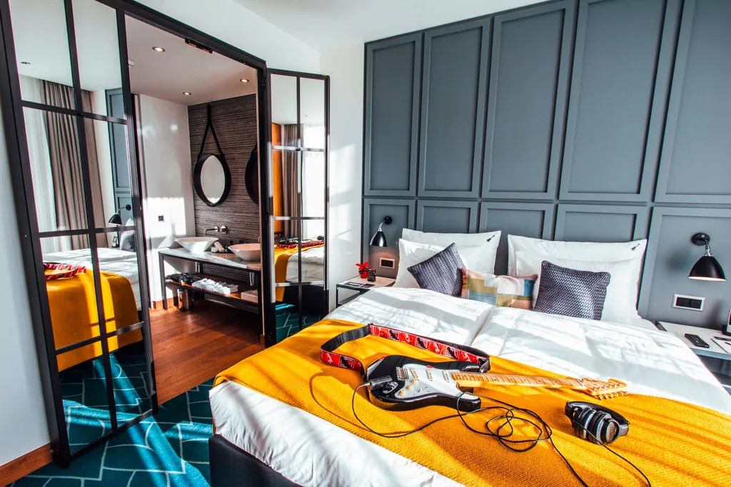 Doppelzimmer mit gelber Tagesdecke und Gitarre im Hard Rock Hotel Davos