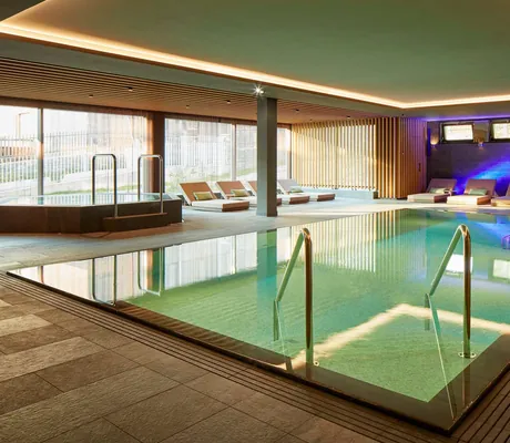 Indoorpool mit blauem Licht im Hintergrund im Hard Rock Hotel Davos