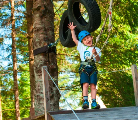 Junges Kind mit Klettergurt im Kletterpark