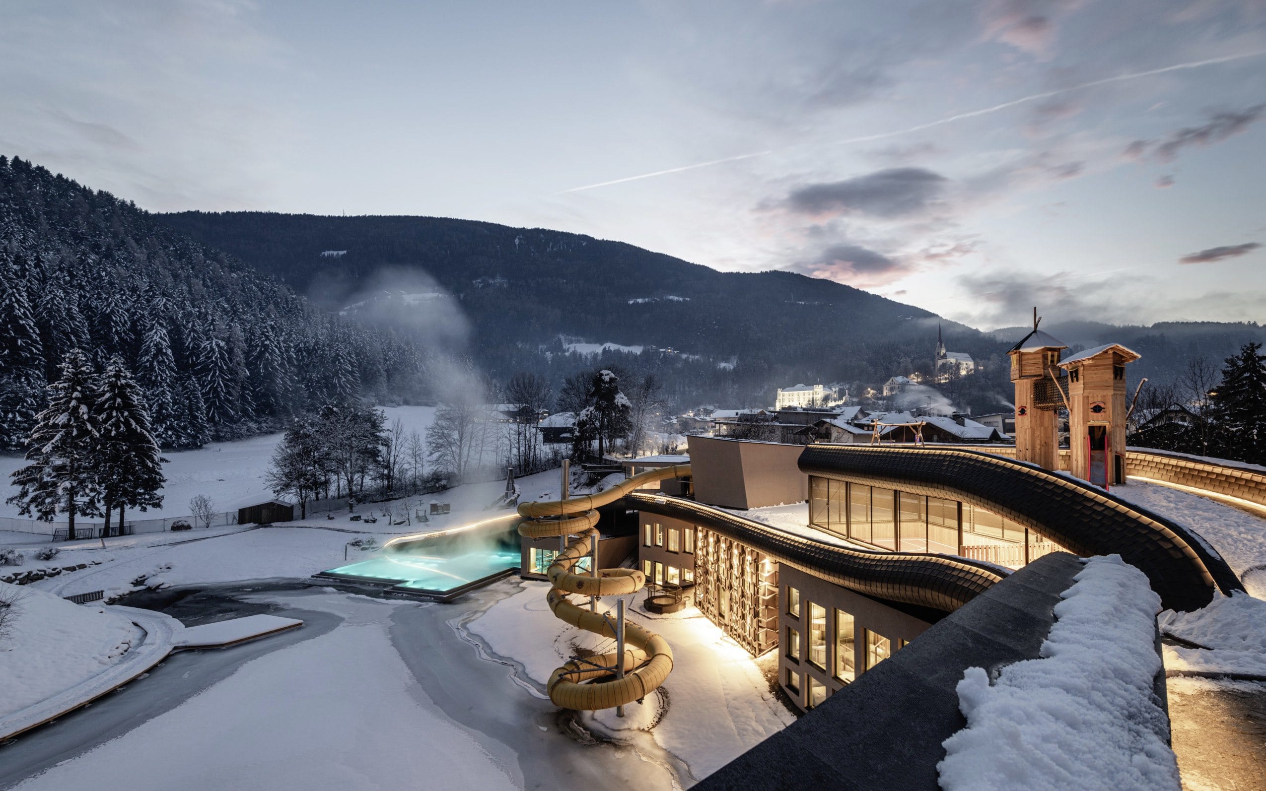 Blick auf das Hotelgebäude des Falkensteiner Family Resort Lido im Winter mit Outdoorpool