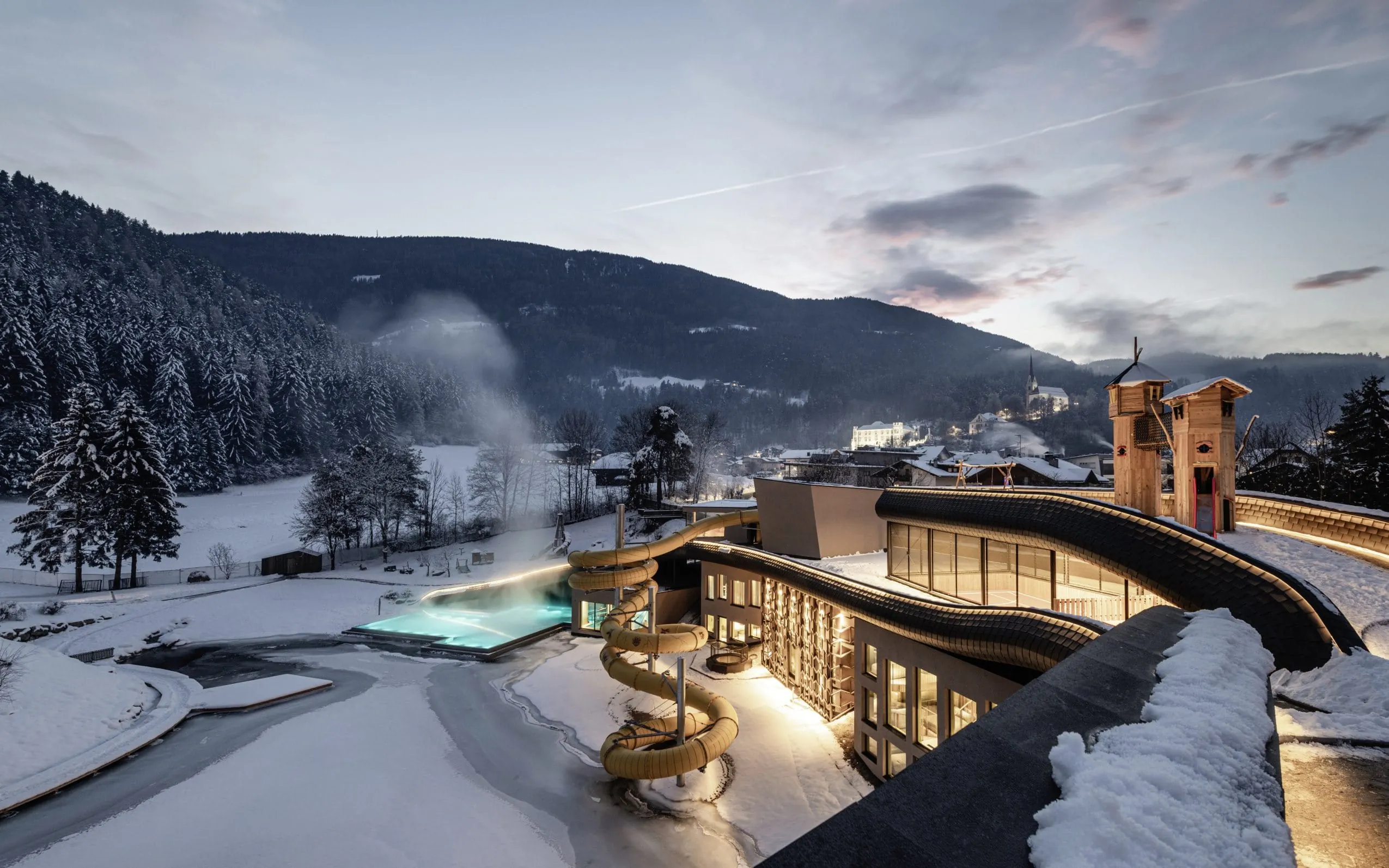 Blick auf das Hotelgebäude des Falkensteiner Family Resort Lido im Winter mit Outdoorpool