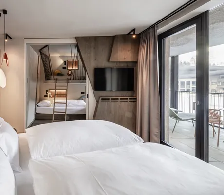 Modern gestaltetes Familienzimmer im Falkensteiner Family Resort Lido mit Doppelbett und Schlafkojen