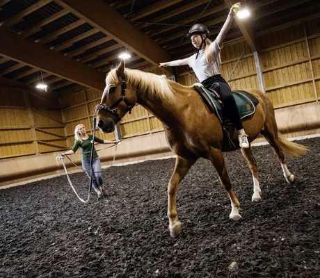 Jugendliche bei einer Reitstunde in der Halle im Familotel Elldus Resort