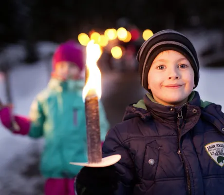 Junge mit brennender Fackel bei Winterwanderung rund um das Familotel Kaiserhof