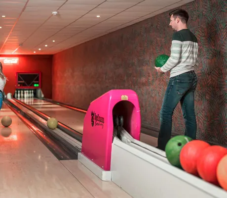 Eine Frau und ein Mann beim Kegeln auf der hauseigenen Kegelbahn des Sporthotel Aktiv und Vital Hotel Thüringen