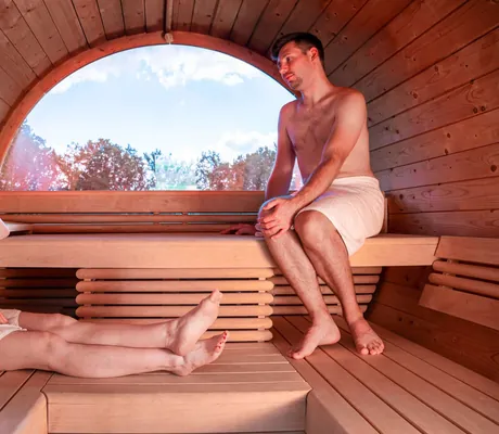 Eine Frau und ein Mann sitzen in einer Sauna im Sporthotel Aktiv und Vital Hotel Thüringen