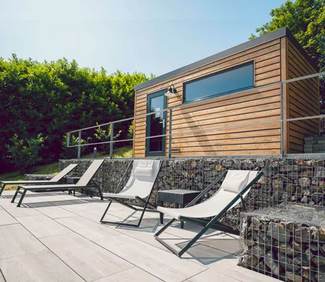 Liegen vor der modernen Holzhütte in der Halfenstube