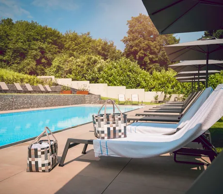 Liegen mit Handtüchern und Wellnesskörben am Pool in der Halfenstube