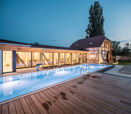 Outdoorpool in der Dämmerung neben dem Mühlrad in Jordan's Untermühle