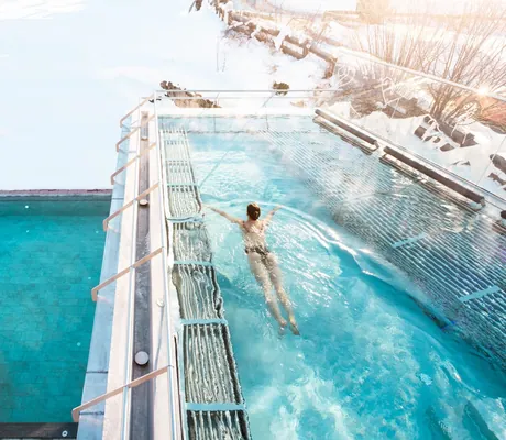 Frau schwimmt im Terrassen-Outdoorpool im Klosterbräu