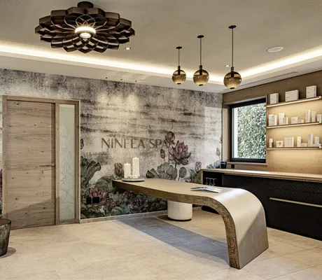 geboegener Tresen im Empfangsbereich mit Seerosen-Tapete im SEELEITEN - Lake Spa Hotel