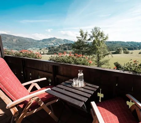 Ein Balkon mit zwei Stühlen und einem Tisch im Wellnesshotel Mittelburg