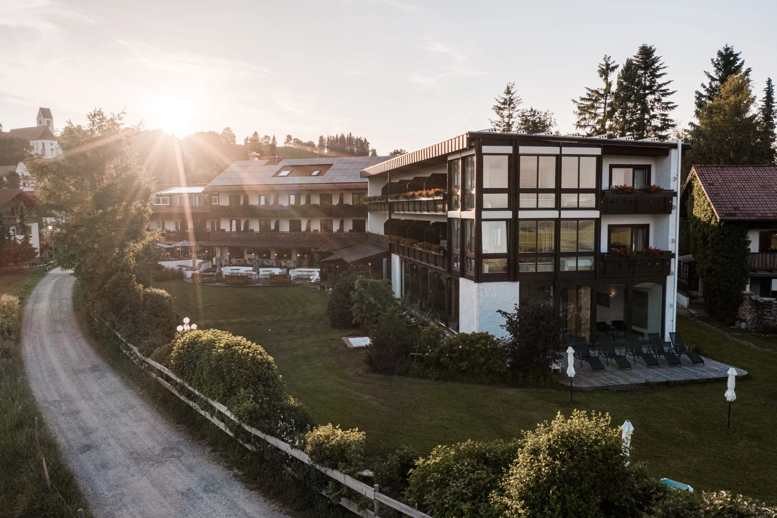 Blick auf den Garten des Wellnesshotel Mittelburg im Allgäu bei Sonnenuntergang