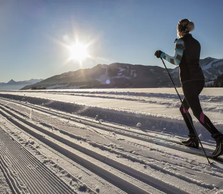 Eine Frau beim Langlaufen bei strahlendem Sonnenschein unweit des Wellnesshotel Mittelburg