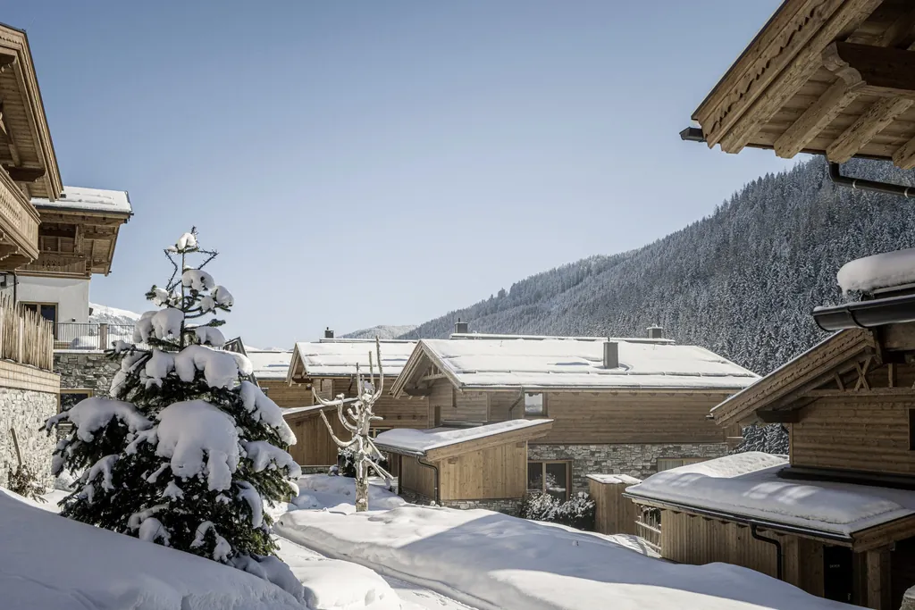 Blick auf die winterlichen Chalets des Farm Resort Geislerhof in Österreich